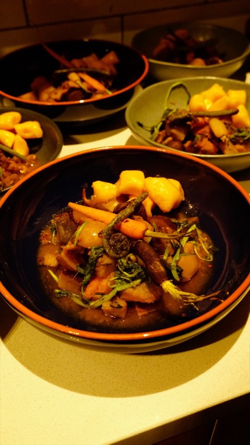 Bowls of &ldquo;flash boil up&rdquo;: a dark broth with baby carrots, fern fronds, greens and golden dumplings